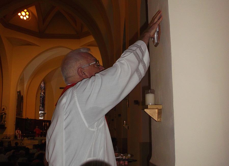 El párroco unge las columnas del templo