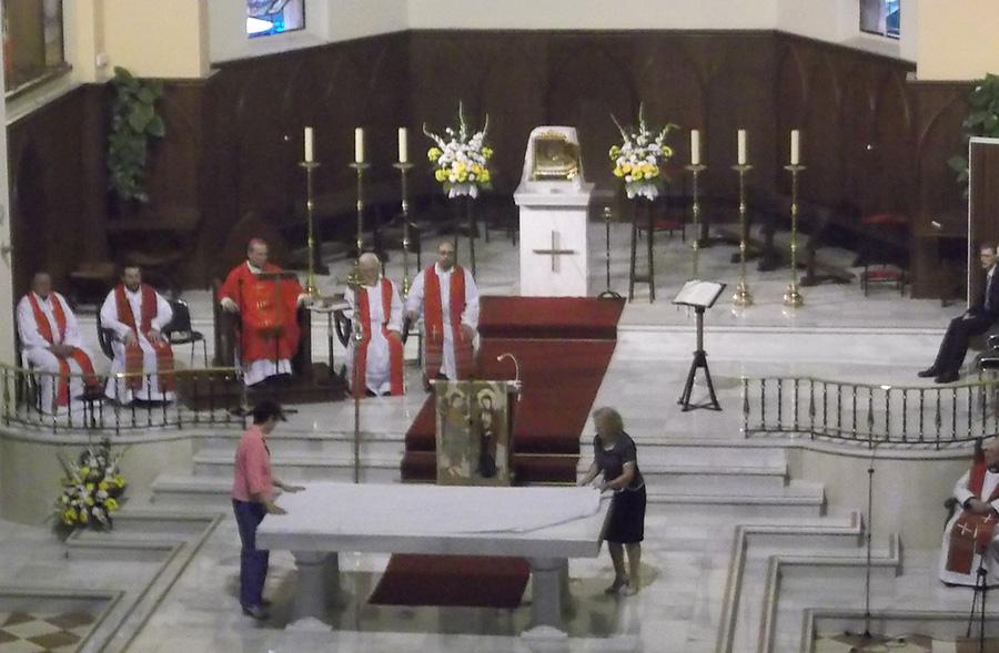 Miembros de la comunidad parroquial visten el altar