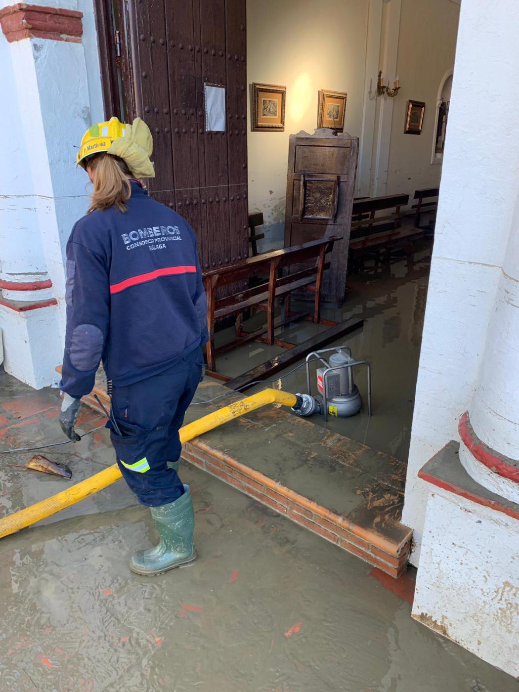 Bomberos sacan agua de la parroquia de San Isidro Labrador, en El Trapiche, tras la inundación de la pedanía