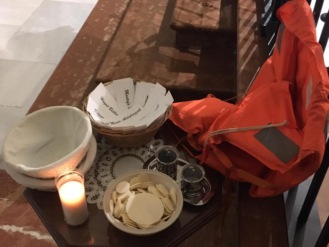 Ofrendas junto a la Cruz de Lampedusa en la parroquia del Carmen, en El Perchel // V. FLORES