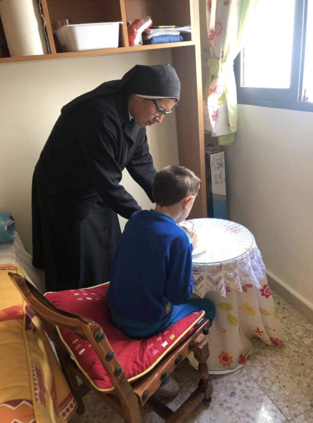 La Madre Agustina atendiendo a uno de los niños durante una convalecencia.