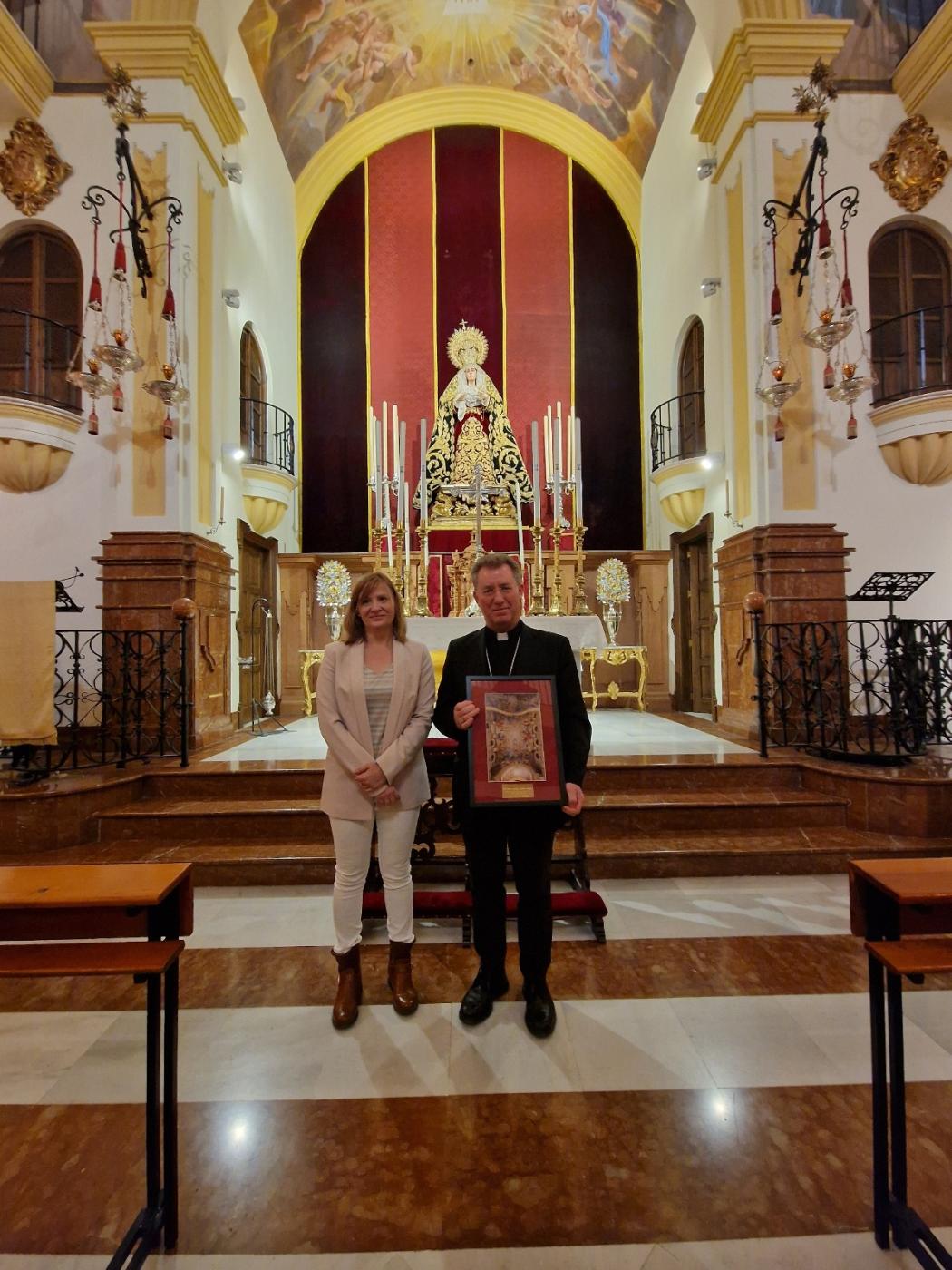 La hermana mayor de la cofradía de las Penas, Ángela Guerrero, entregó un recuerdo de la cofradía a Mons, Aurelio García tras su visita a la Casa Hermandad